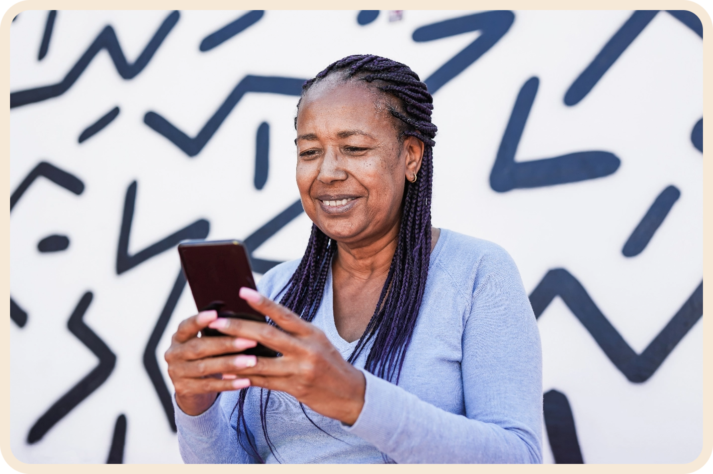 african american older woman smiling and looking at phone